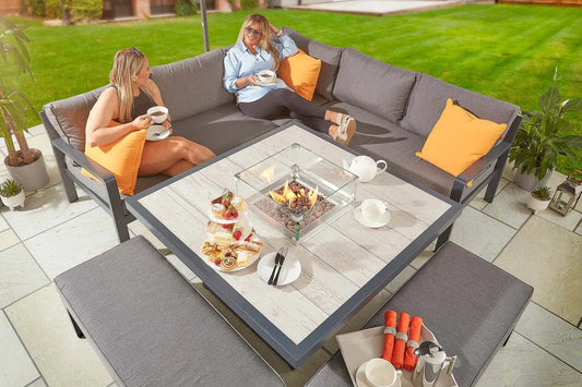 The Tutbury Fire Pit Table Garden Set creates an inviting outdoor living space. This patio set includes a propane fire pit table, corner sofa, and two benches to comfortably seat up to 5 people around flickering flames. Durable steel construction built to withstand weather and heavy use for years.